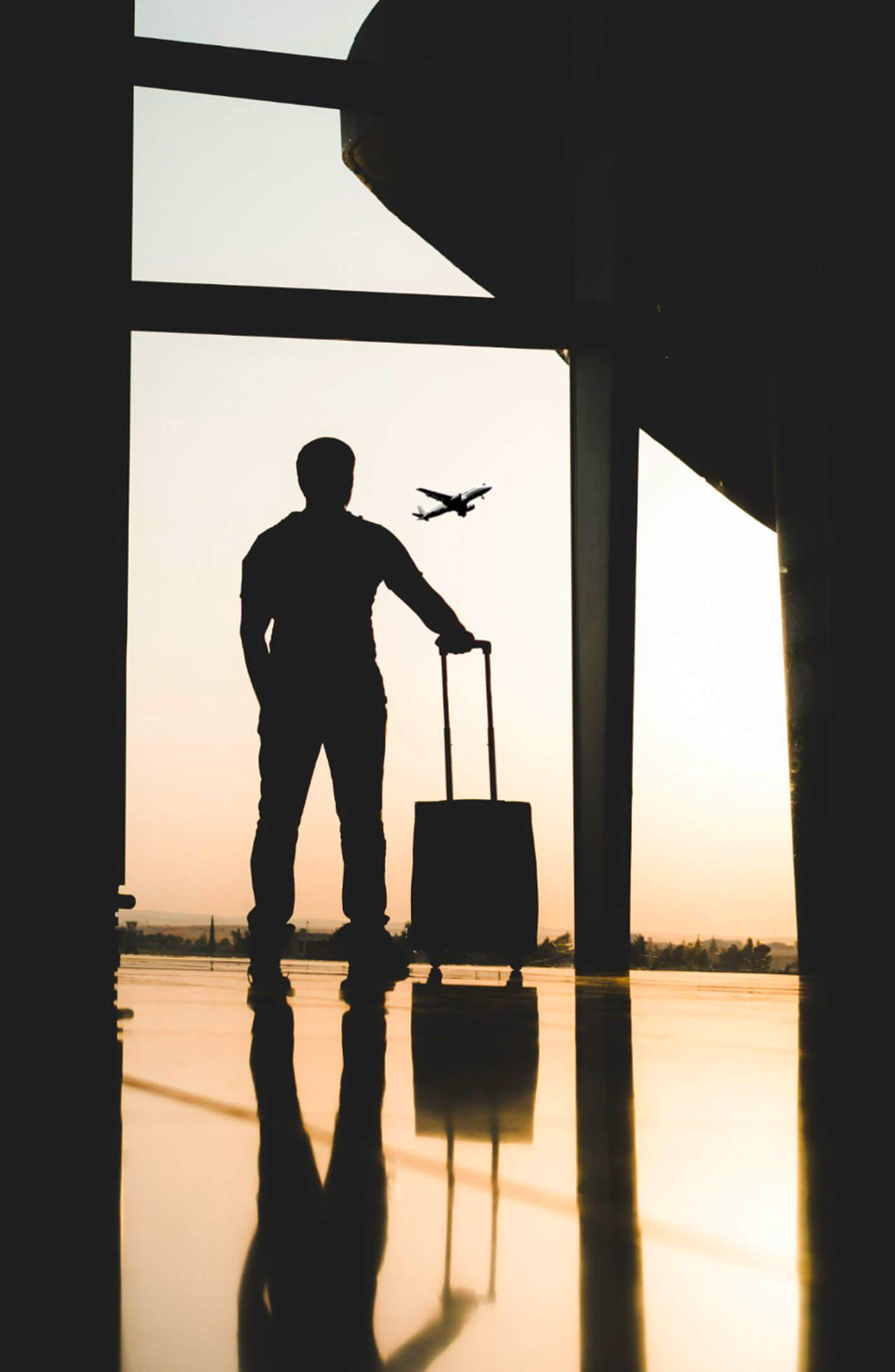 Traveler with a suitcase watching a plane take off